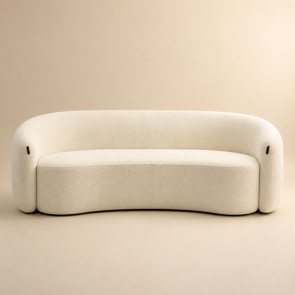 Anse Sofa in cream bouclé seen straight on, the barrel back wrapping from arm to arm