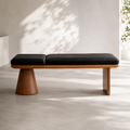Aubin Bench with black seat pads on a walnut frame, on a conical pedestal at one end and a slab leg at the other