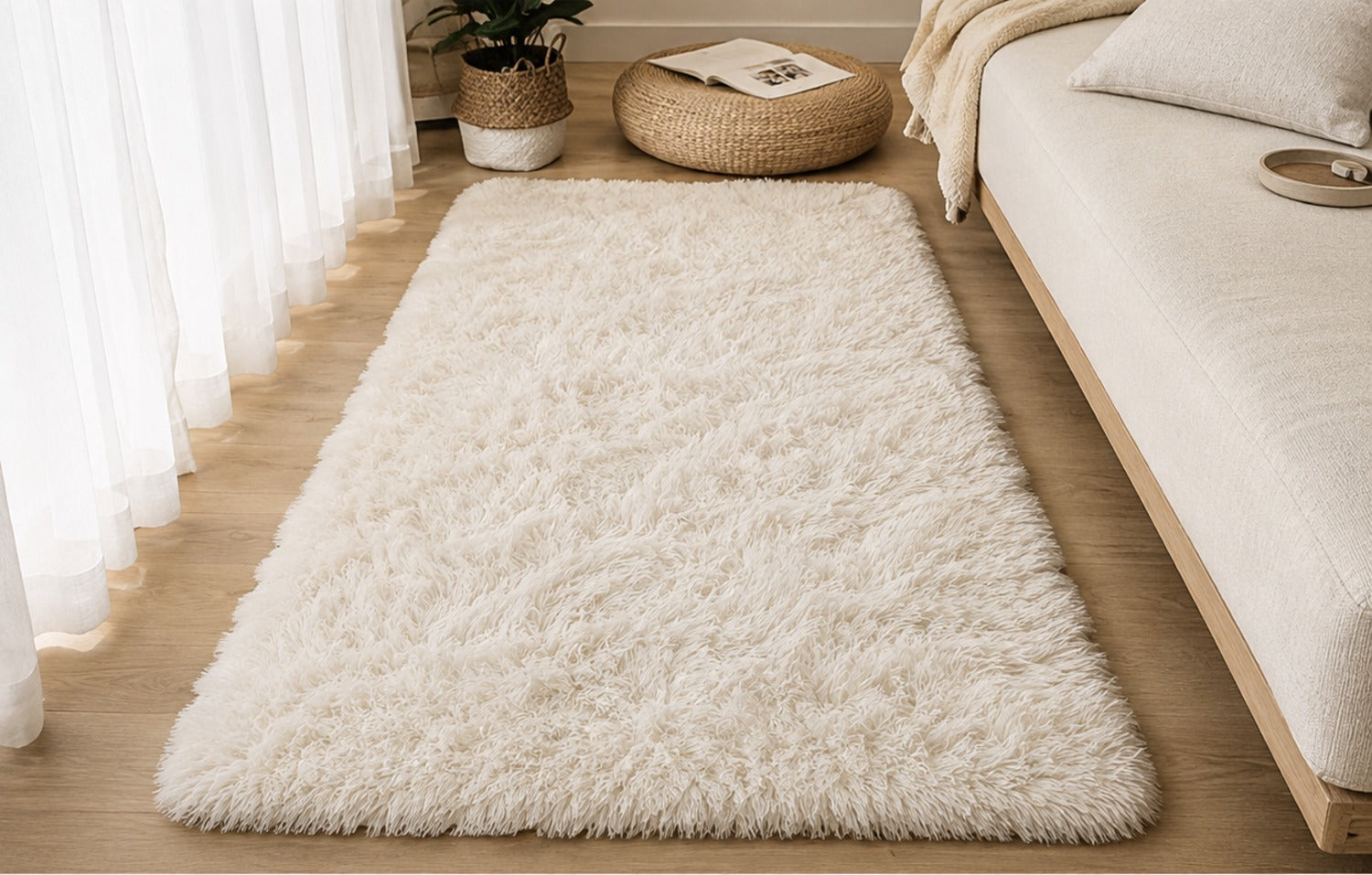 Aveline Plush Rug in beige on a light wood floor beside a low bed