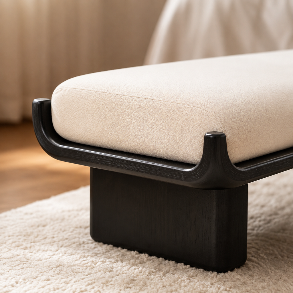 Close view of the open wood grain under the black finish, the turned tip of the cradle and the plinth leg below