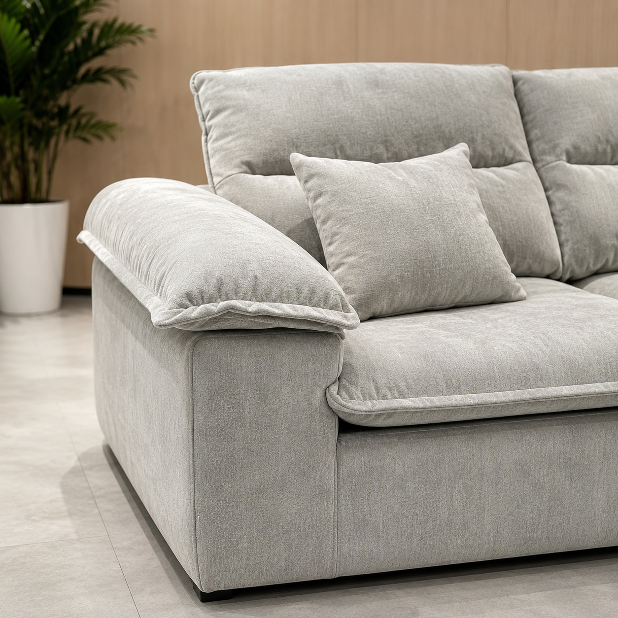 Close view of the Brume Sofa, the bolster arm resting on the frame above the plinth