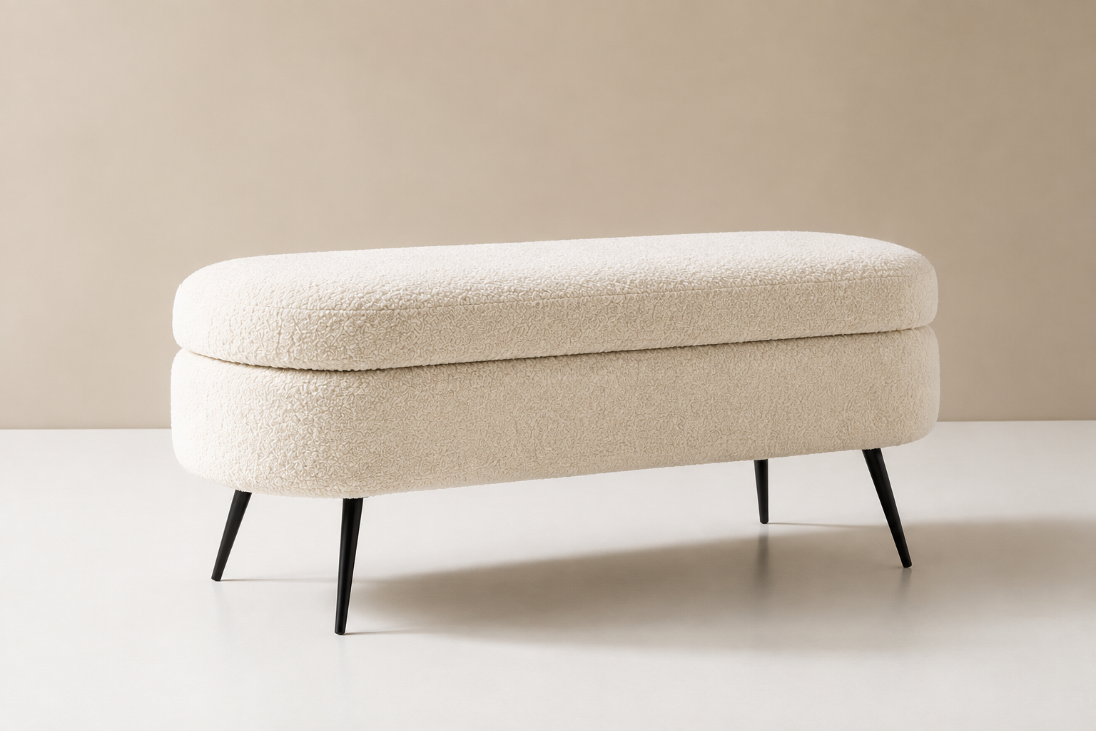 Cocon Bench in cream bouclé, a rounded oval seat on four slim black tapered legs