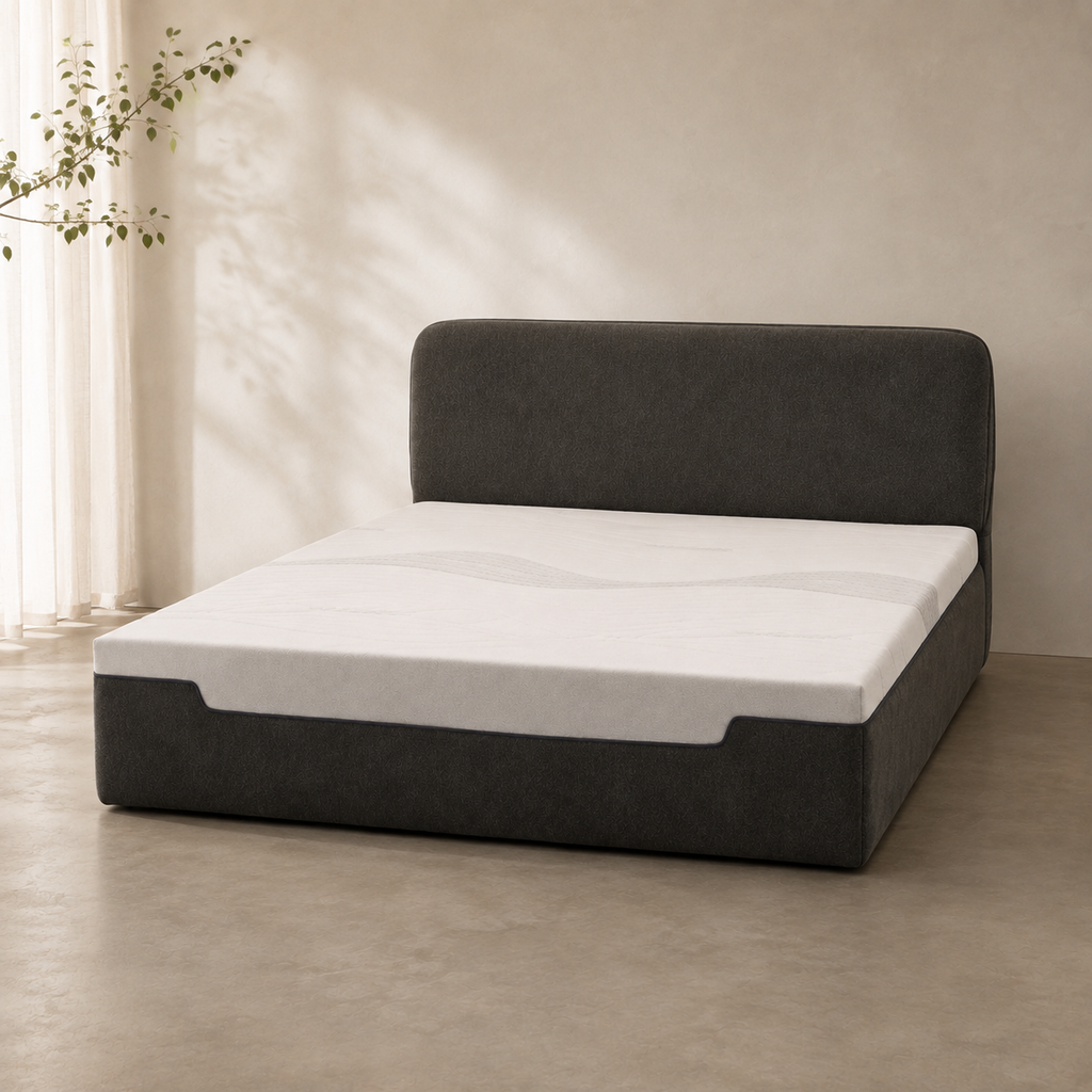Liseré Bed in charcoal, the piped headboard rising behind a deep upholstered base