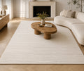 Linéa Rug in ivory in a panelled room with a fireplace and a curved boucle sofa
