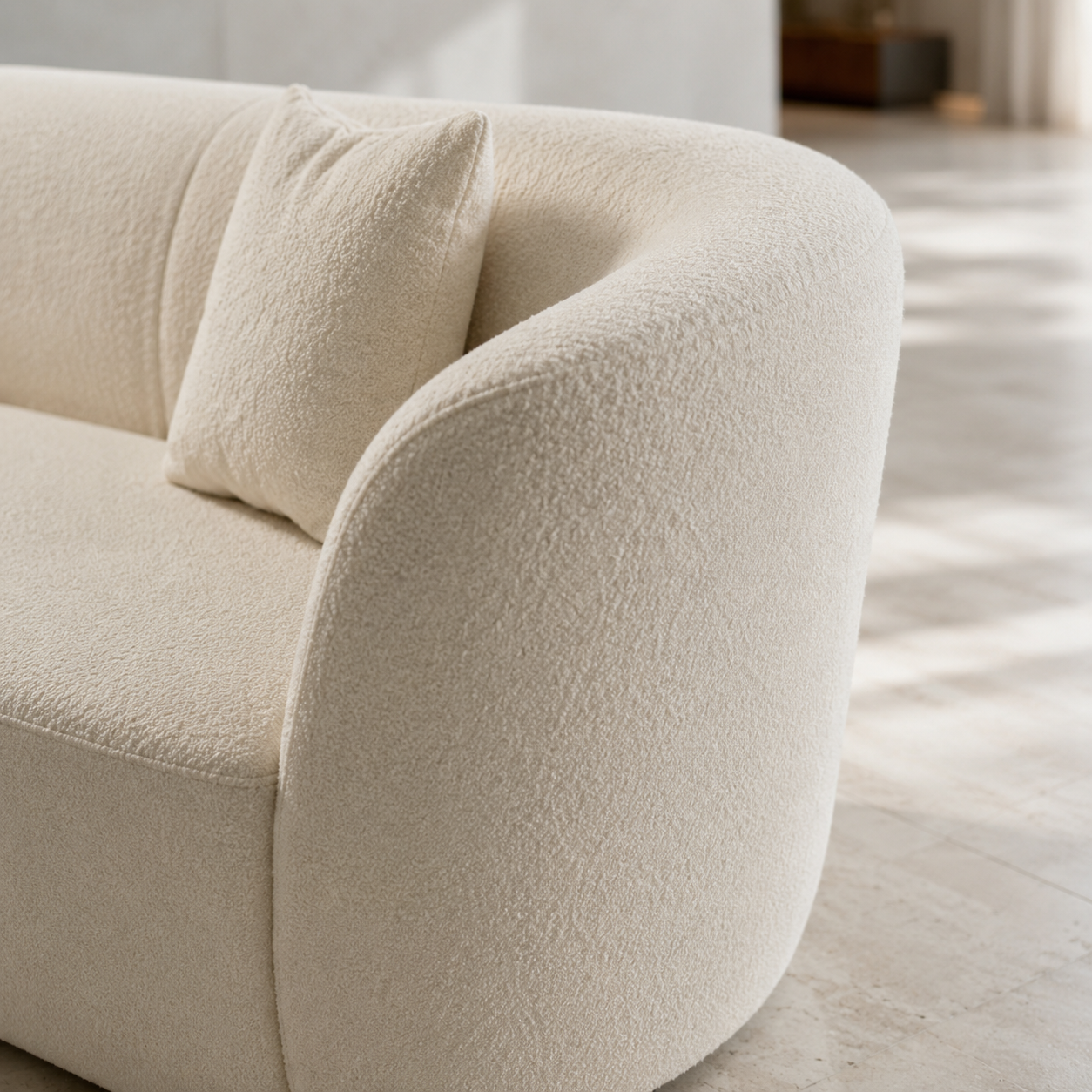 Close view of the Lune Sofa arm, the bouclé curling forward where the back ends