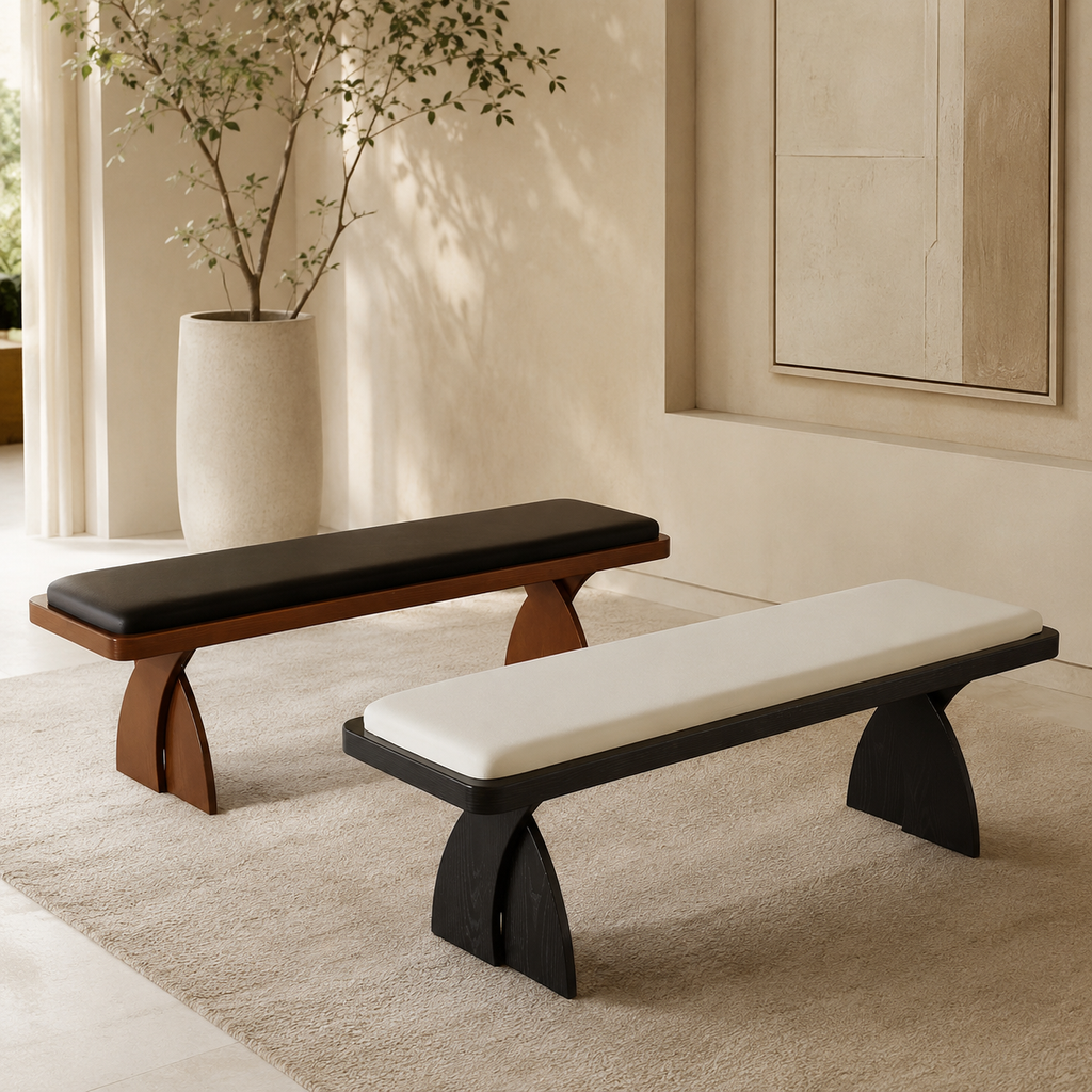 Marane Bench in both finishes on a wool rug: a walnut frame with a black pad and a black frame with a cream pad, on arched crossed legs