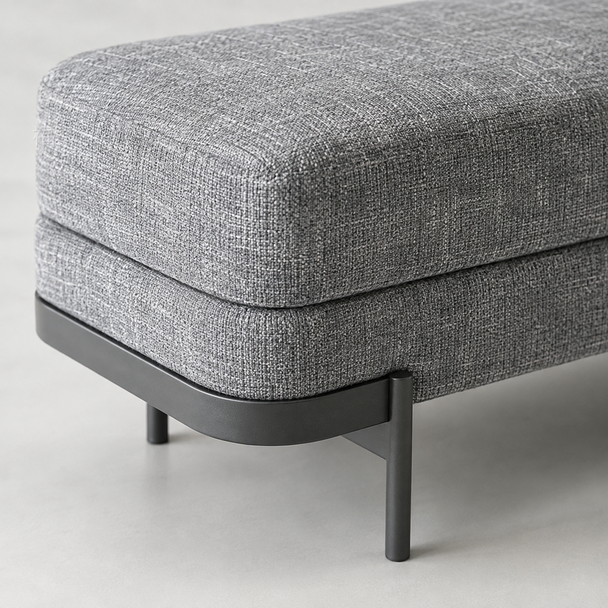 Close view of the woven grey fabric, the seam under the seat and the black steel foot