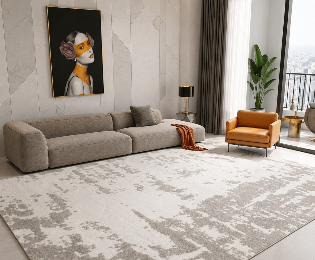 Rylan Noble Rug in ivory and taupe across a large living room with a grey sofa and a tan leather armchair