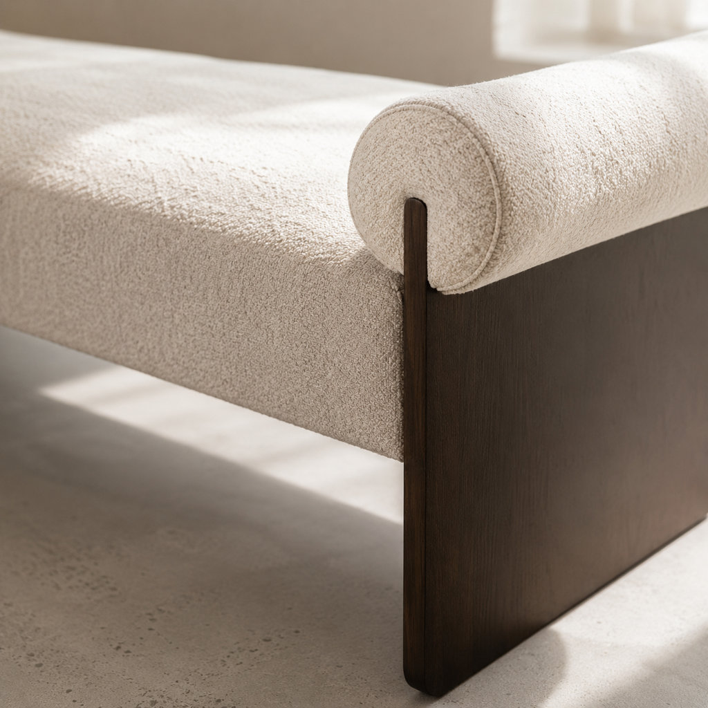 Close view of the cream boucle bolster resting against the dark stained wood leg