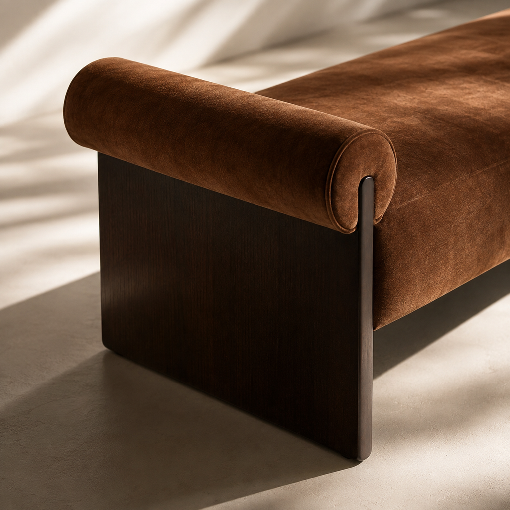 Close view of the rust velvet bolster and the dark stained wood leg