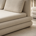 Strate Bed in cream bouclé, three stacked slabs with two loose back cushions, a night stand beside it
