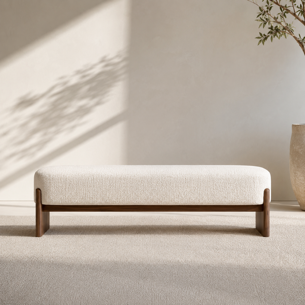 Traverse Bench seen straight on, the cream bouclé cushion sitting in its solid wood frame above a long stretcher rail