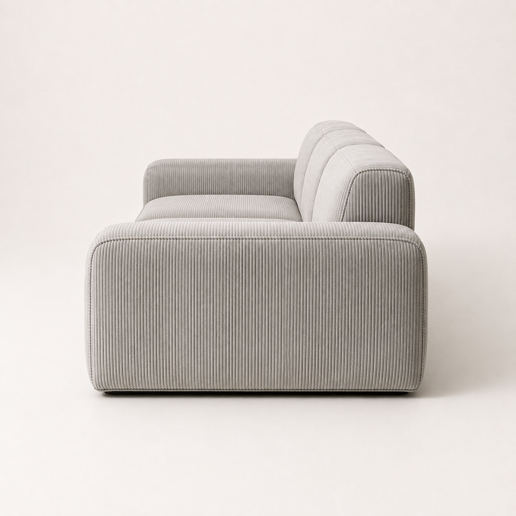 Triptyque Sofa from the side, showing the depth of the arm and the recessed dark base