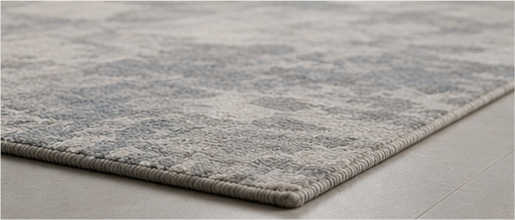 Close view of the Valori Rug's woven edge on a pale stone floor